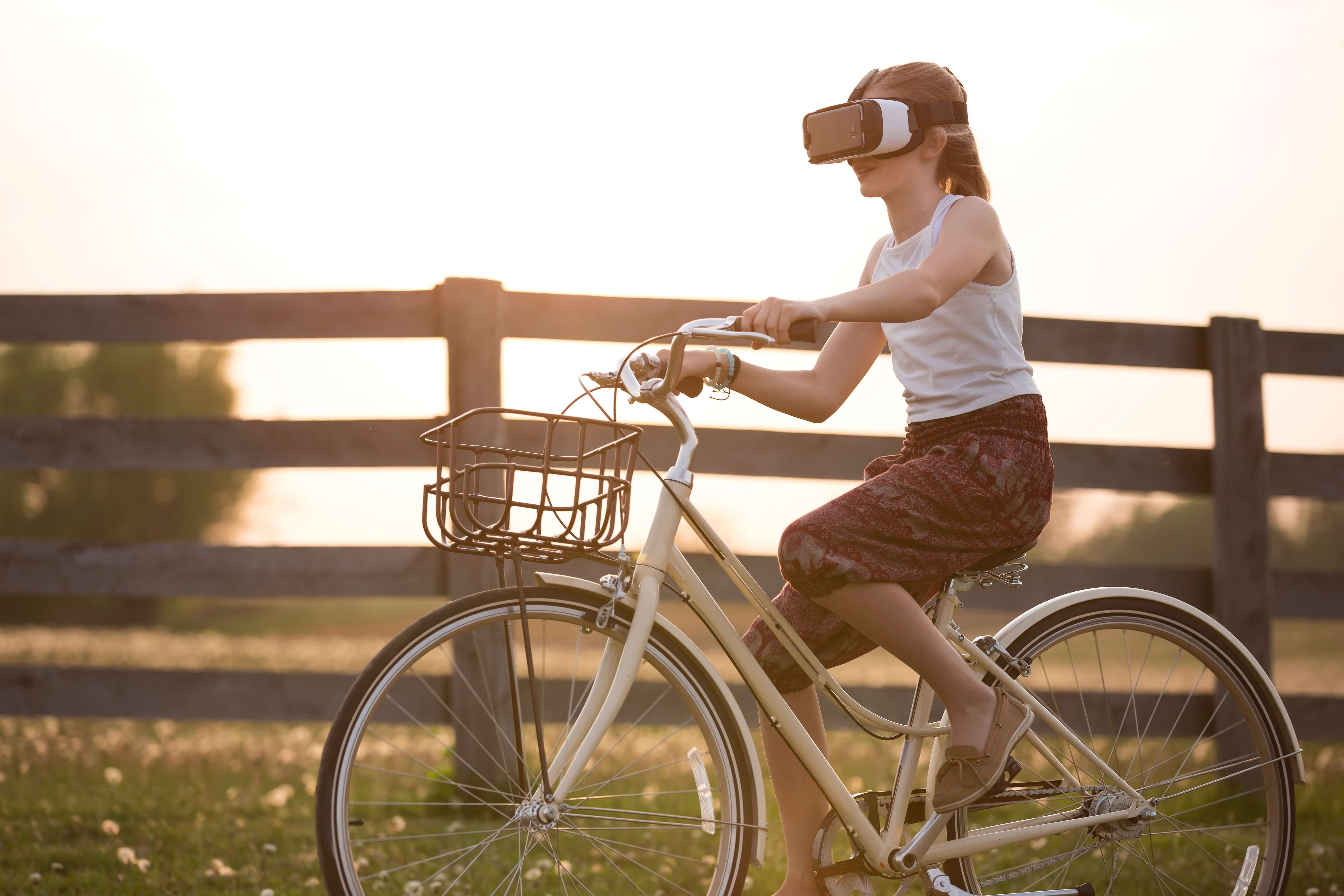 Junge Frau fährt mit VR-Brille Fahrrad